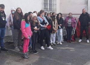 Młodzież ogląda pokaz tresury psa