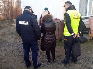 Policjant, strażnik miejski i pracownik OPS kontrolują miejsce pobytu bezdomnego