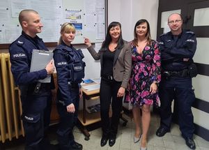 Policjanci rozwieszają plakaty w różnych instytucjach