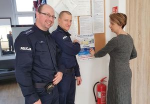 Policjanci rozwieszają plakaty w różnych instytucjach