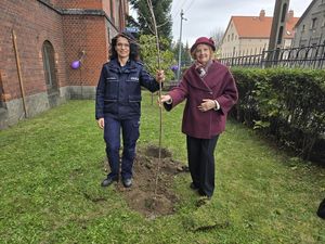 Symboliczny dar od Towarzystwa Miłośników Dzierżoniowa z okazji 100-lecia kobiet w Policji. Wsadzanie lilaków przed budynkiem KPP Dzierżoniów.