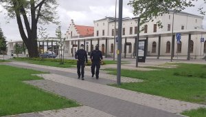 Policjanci w patrolu na tle centrum przesiadkowego