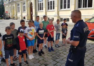 Funkcjonariusz prowadzi prelekcję na temat bezpiecznego wypoczynku nad wodą i bezpiecznych wakacji